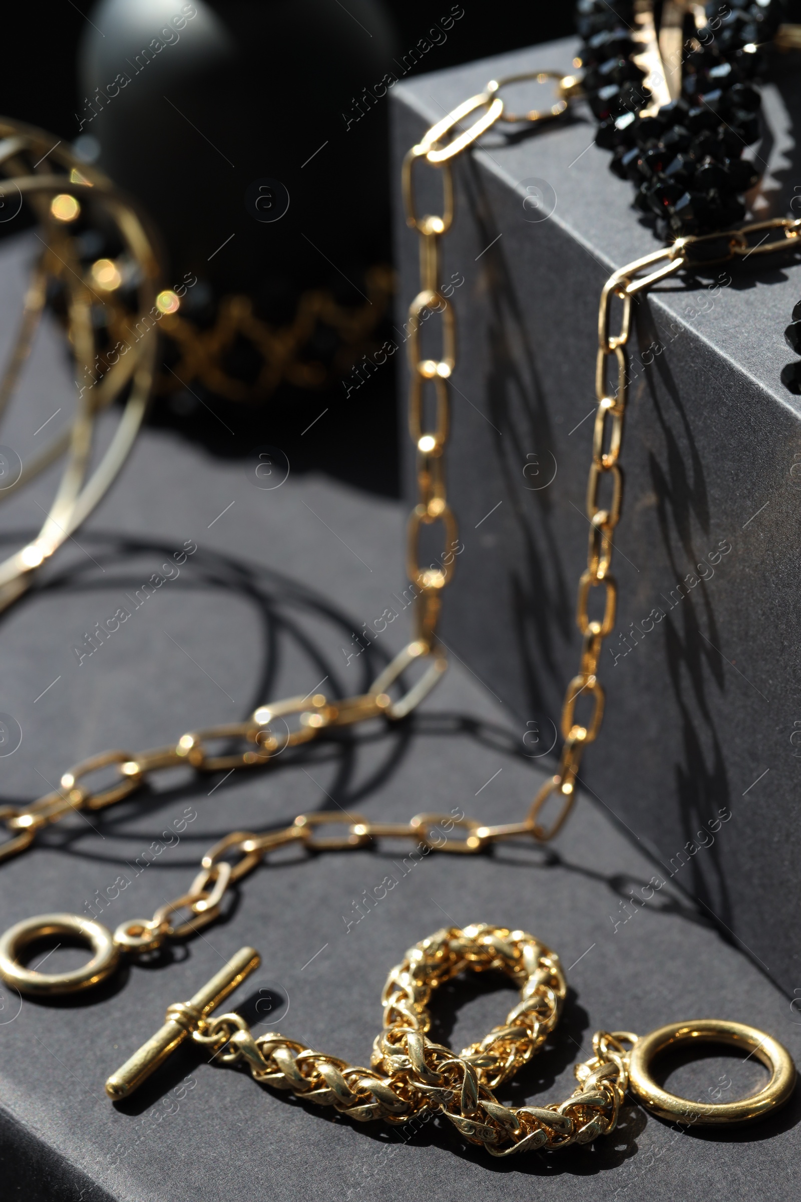 Photo of Presentation of metal chains on black table, closeup. Luxury jewelry