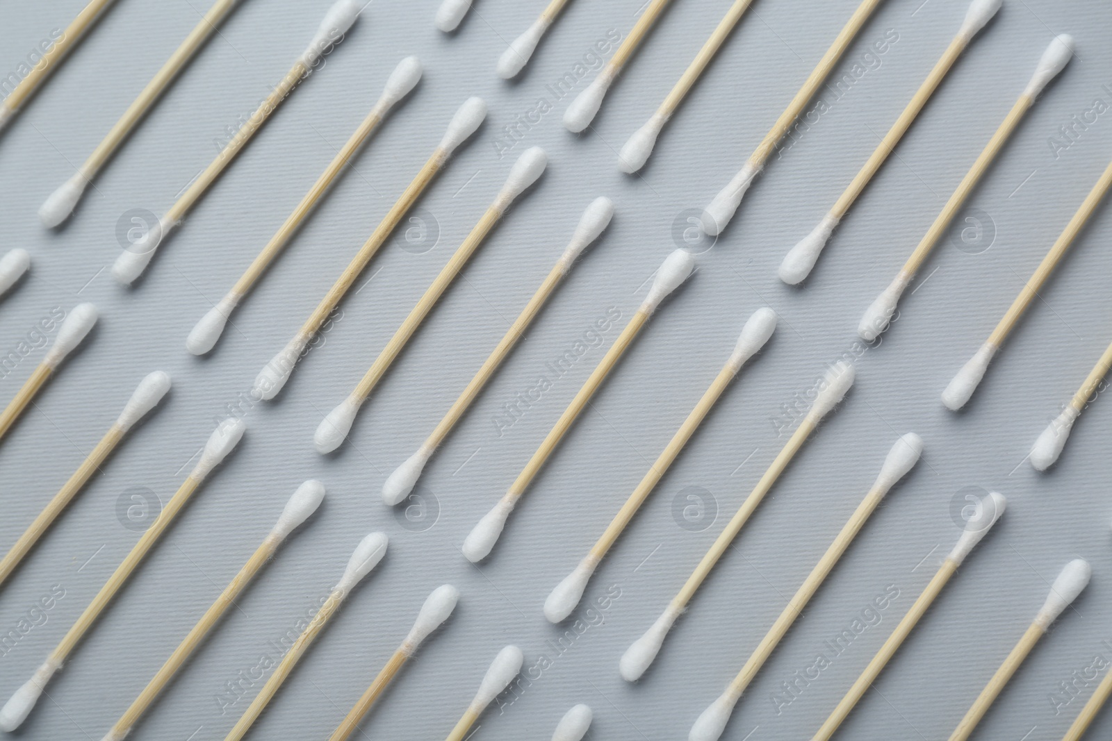 Photo of Many wooden cotton buds on light grey background, flat lay