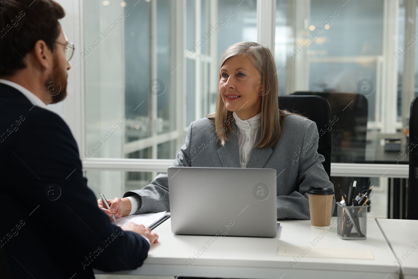 Photo of Lawyer working with client at table in office