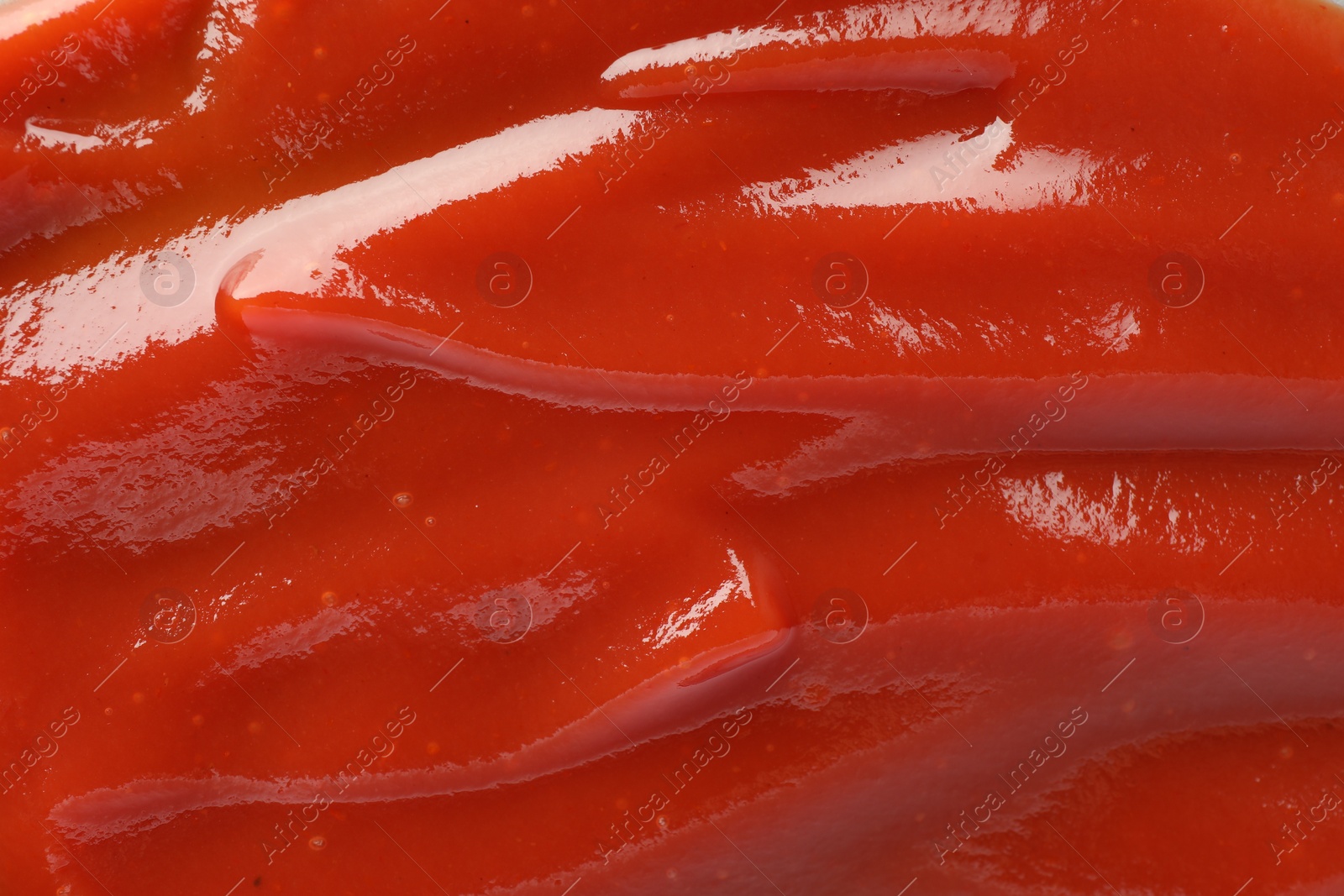 Photo of Tasty tomato ketchup as background, top view