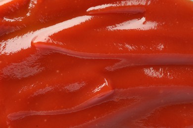 Tasty tomato ketchup as background, top view