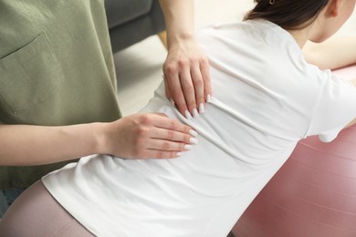 Photo of Doula massaging pregnant woman at home, closeup. Preparation for child birth