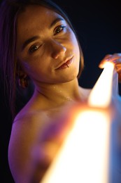 Beautiful woman with lamp on dark background in neon lights