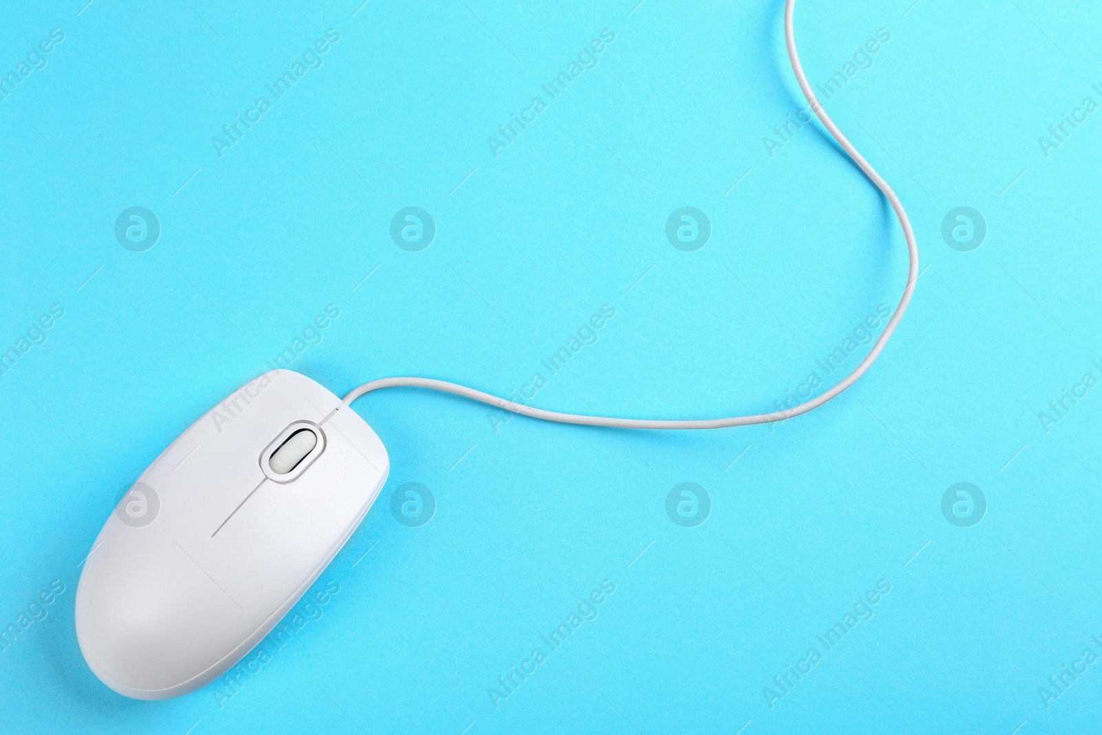 Photo of Modern wired mouse on light blue background, top view