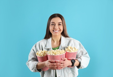Photo of Young woman with tasty popcorn on color background