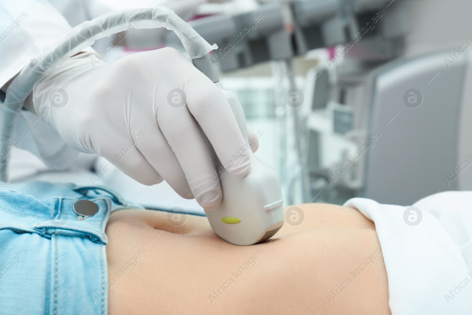 Photo of Doctor conducting ultrasound examination of internal organs in clinic, closeup