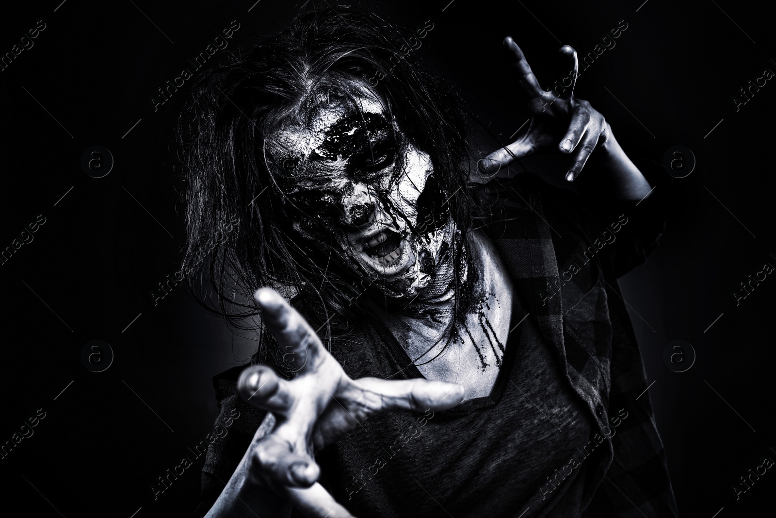 Photo of Scary zombie on dark background, black and white effect. Halloween monster