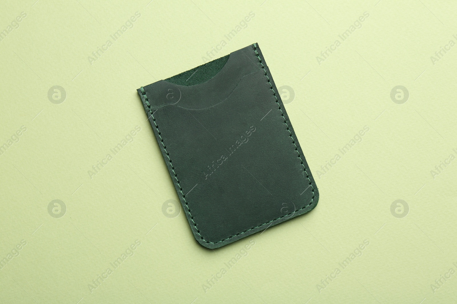 Photo of Empty leather card holder on light green background, top view