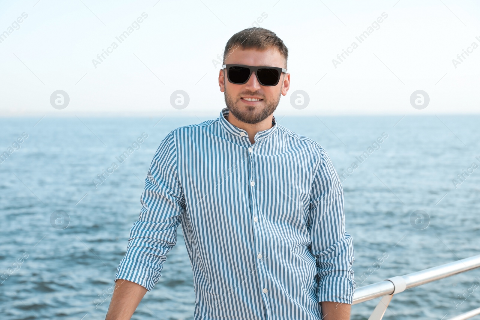 Photo of Portrait of handsome young man on sea pier