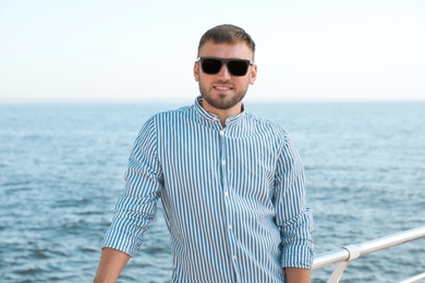 Photo of Portrait of handsome young man on sea pier