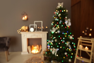 Photo of Blurred stylish room interior with Christmas tree and decorative fireplace