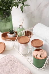 Photo of Personal hygiene products on table near white wall in bathroom