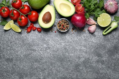 Photo of Fresh guacamole ingredients on grey table, flat lay. Space for text