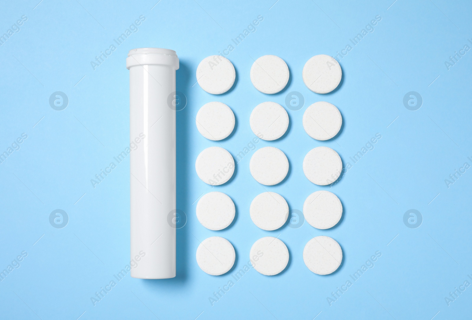 Photo of Container and pills on light blue background, flat lay