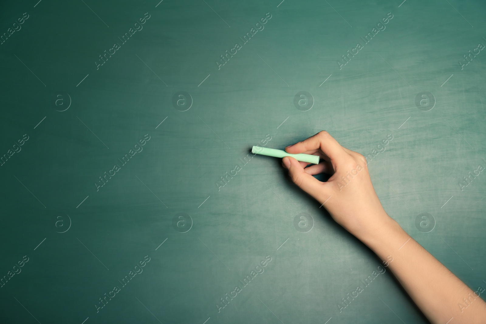 Photo of Woman writing with piece of chalk on board