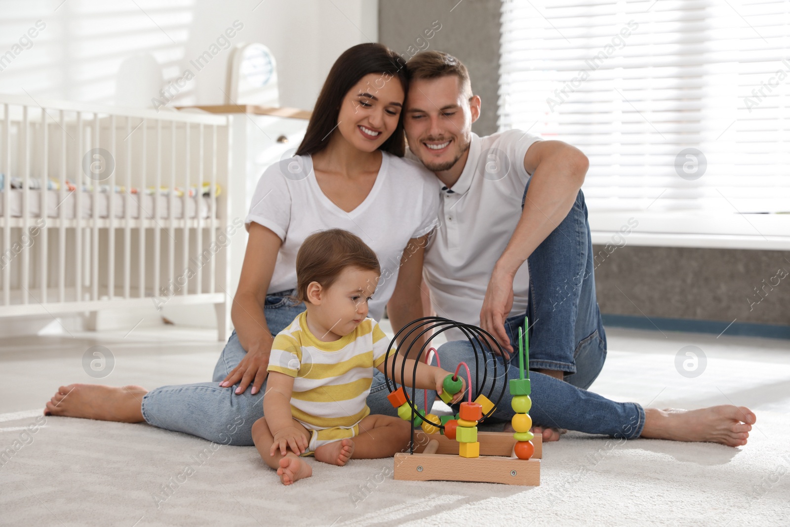 Photo of Happy family with adorable little baby at home