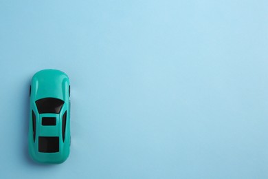 Photo of One bright car on light blue background, top view with space for text. Children`s toy