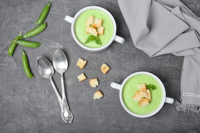 Flat lay composition with green pea soup on grey background