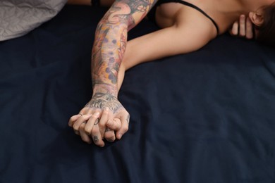 Photo of Passionate young couple having sex on bed, closeup of hands