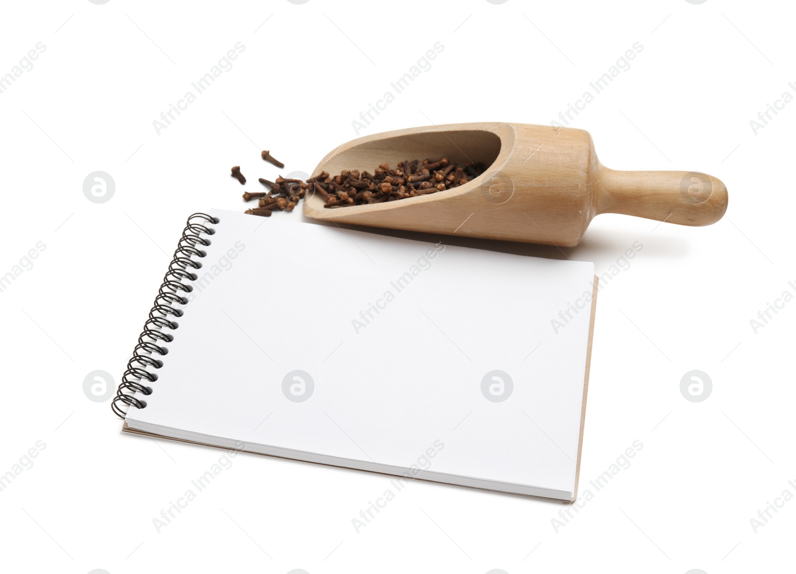 Photo of Blank recipe book, wooden scoop with cloves on white background. Space for text