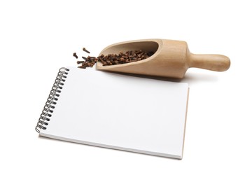 Photo of Blank recipe book, wooden scoop with cloves on white background. Space for text