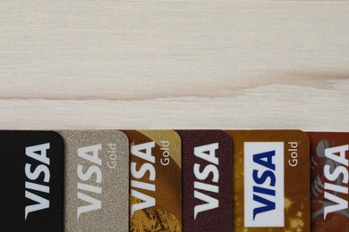 MYKOLAIV, UKRAINE - FEBRUARY 22, 2022: Visa credit cards on white wooden table, flat lay. Space for text