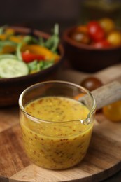 Tasty vinegar based sauce (Vinaigrette) on wooden table, closeup