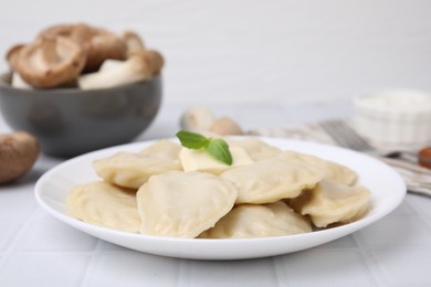 Photo of Delicious dumplings (varenyky) with tasty filling and butter on white tiled table, closeup