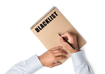 Image of Man writing word Blacklist in notebook on white background, top view