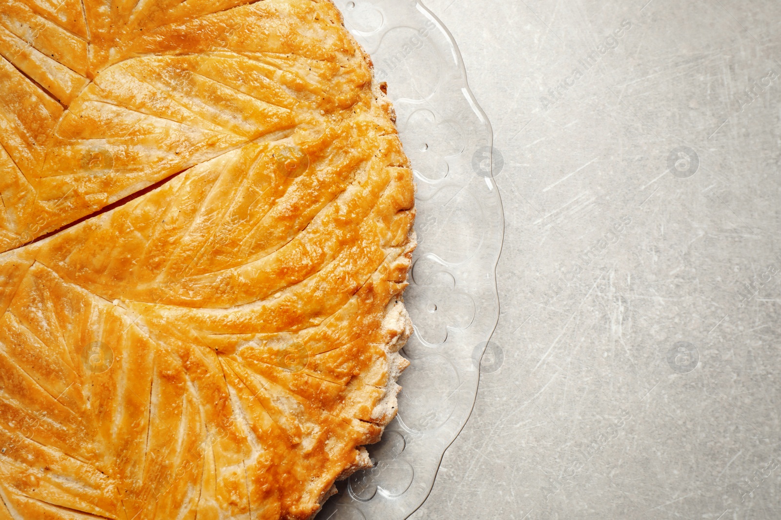Photo of Traditional galette des rois on light grey table, top view. Space for text