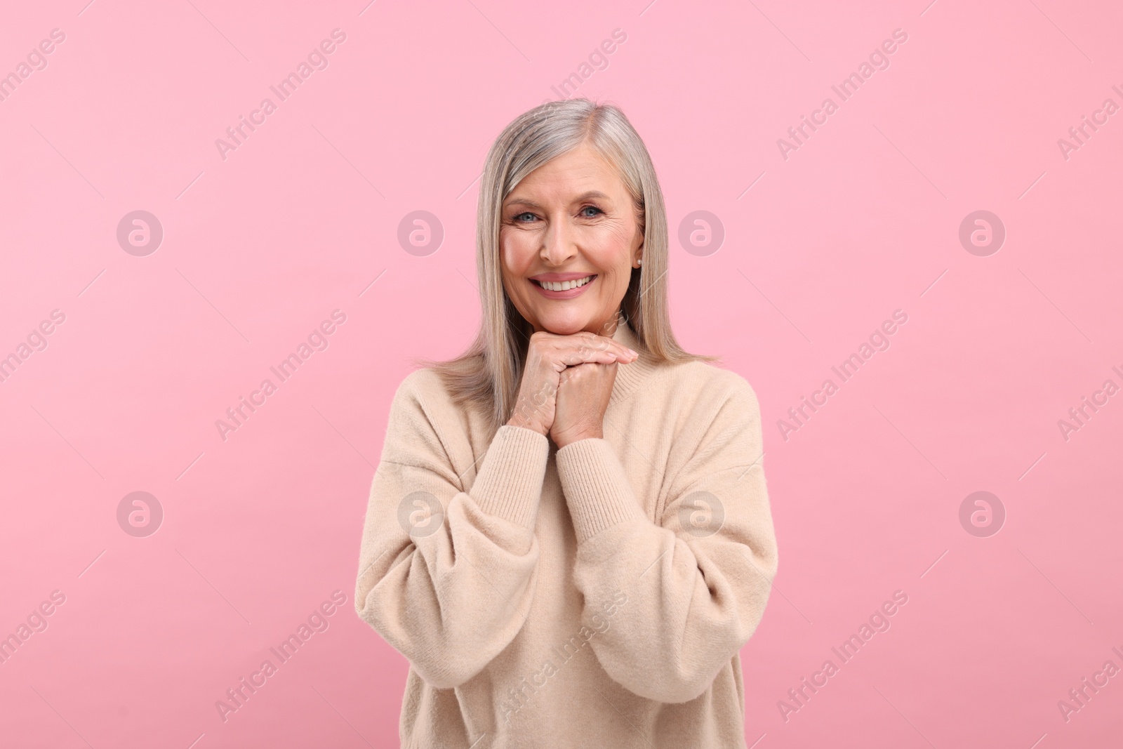 Photo of Portrait of beautiful middle aged woman on pink background