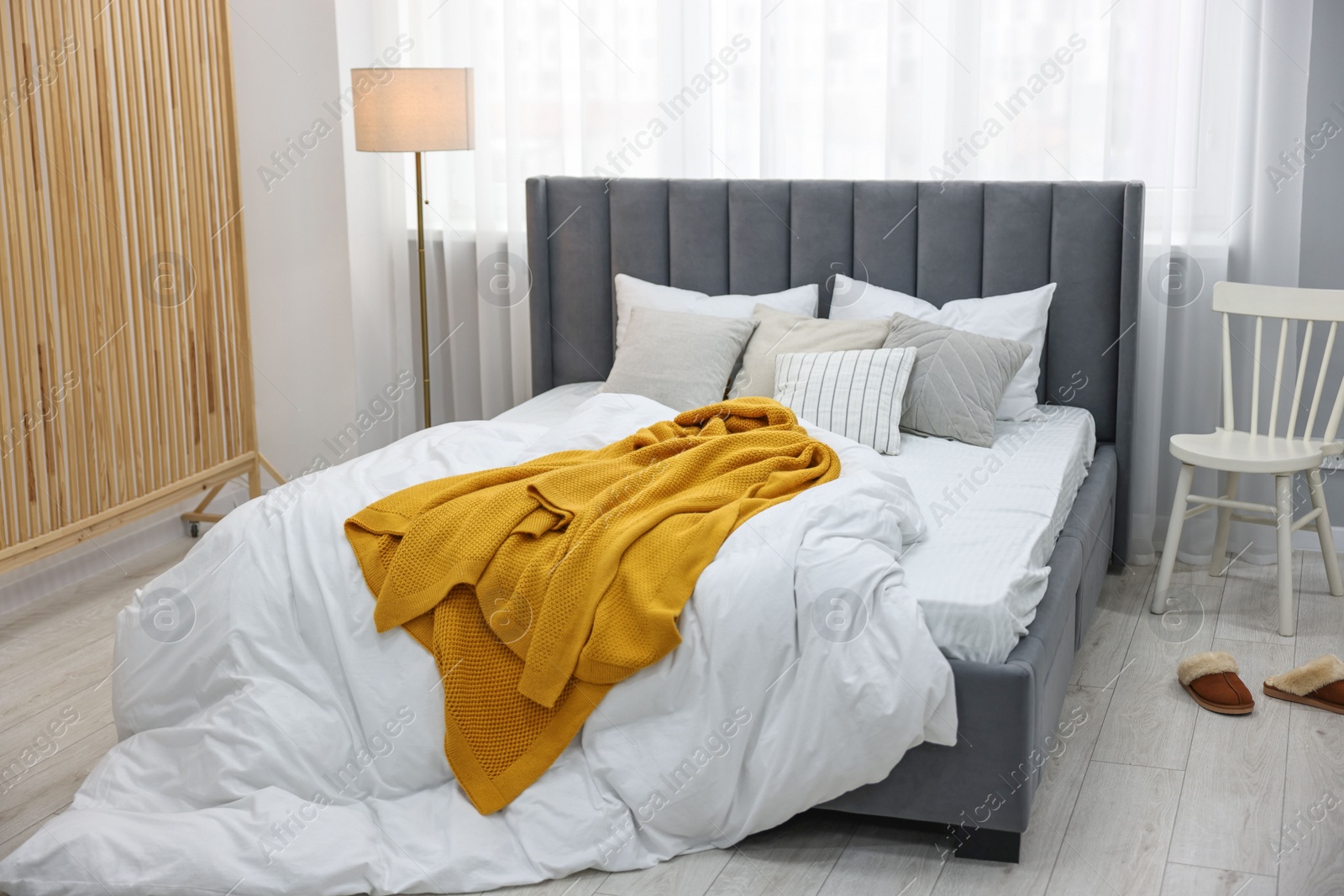 Photo of Bright plaid on bed in stylish bedroom