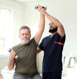 Photo of Physiotherapist working with patient in clinic. Rehabilitation therapy