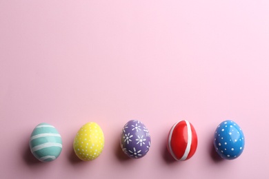 Flat lay composition of painted Easter eggs on color background, space for text