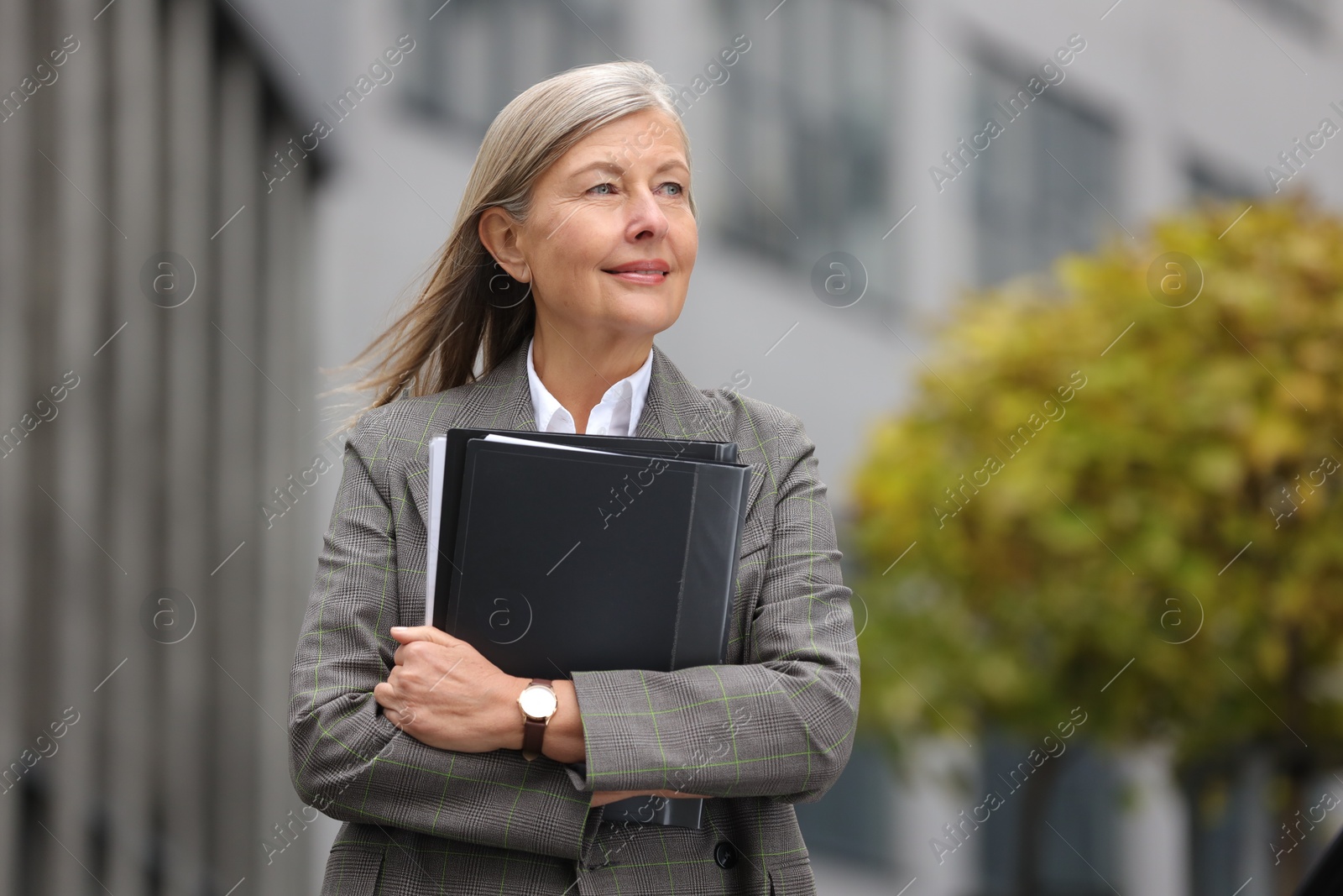 Photo of Beautiful woman with folders outdoors. Lawyer, businesswoman, accountant or manager