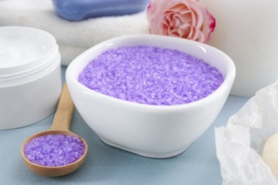 Photo of Sea salt, jar with cream and beautiful rose on light grey background, closeup