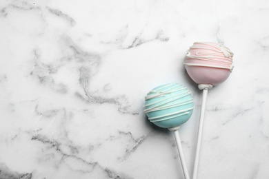 Photo of Sweet colorful cake pops on white background, flat lay. Space for text