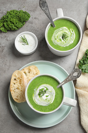 Photo of Tasty kale soup served on grey table, flat lay