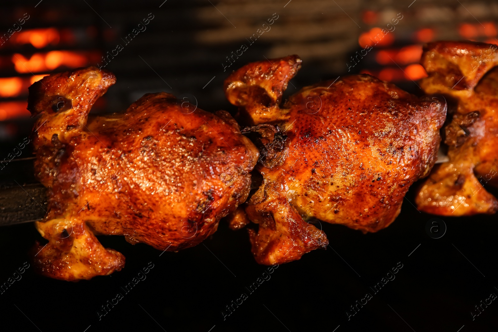 Photo of Grilling whole chickens in rotisserie machine, closeup