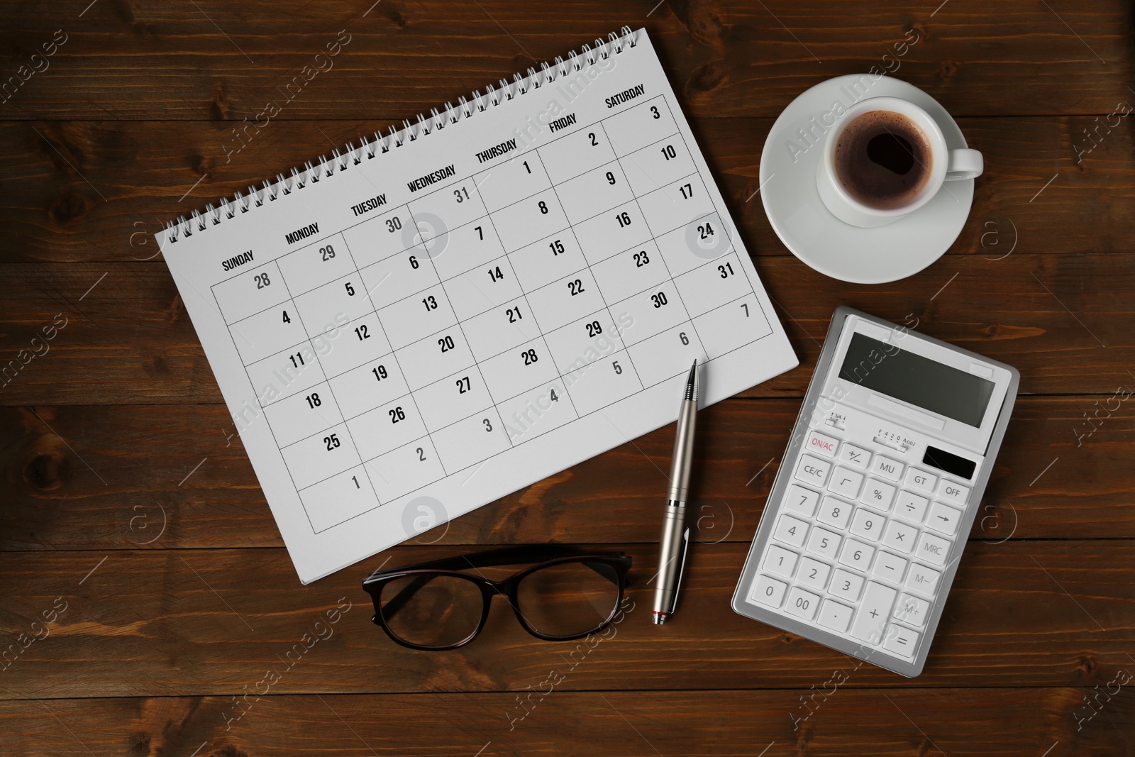 Photo of Flat lay composition with calendar on wooden table