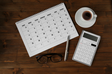 Flat lay composition with calendar on wooden table