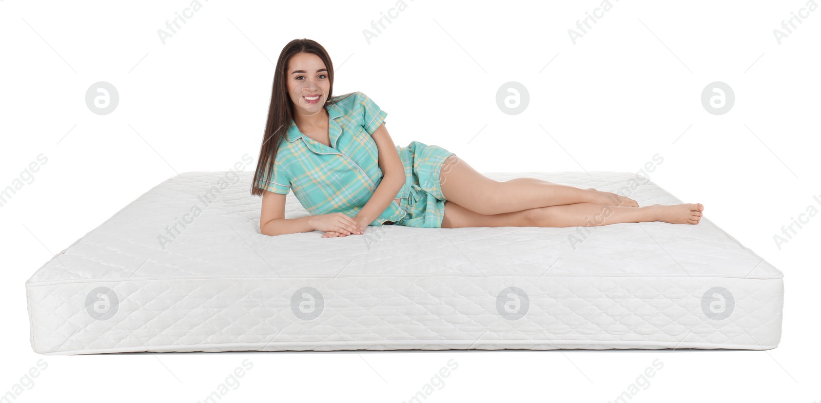 Photo of Young woman lying on mattress against white background