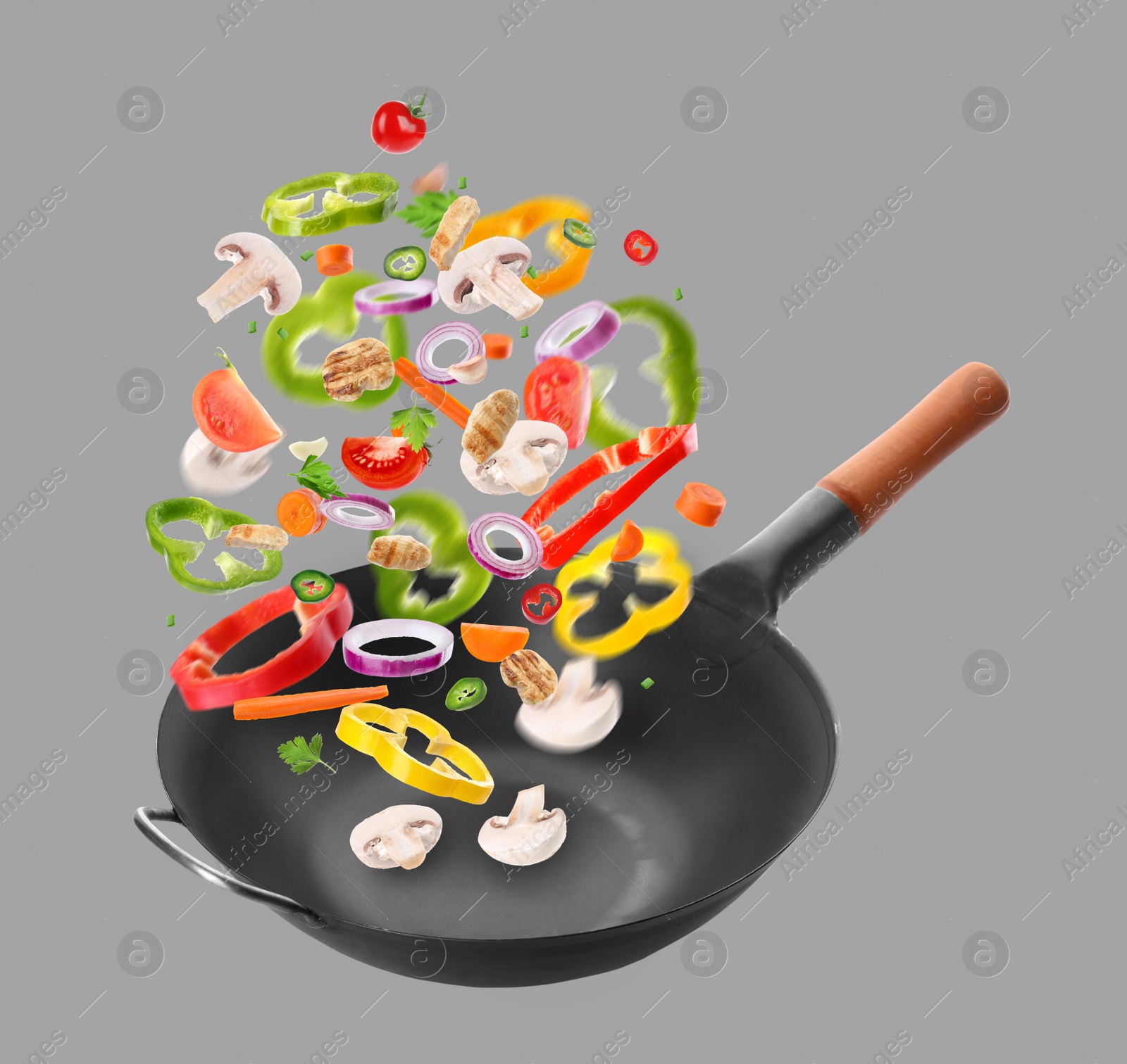 Image of Different tasty ingredients falling into wok on light grey background
