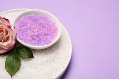 Photo of Aromatic sea salt and beautiful flower on purple background. Space for text