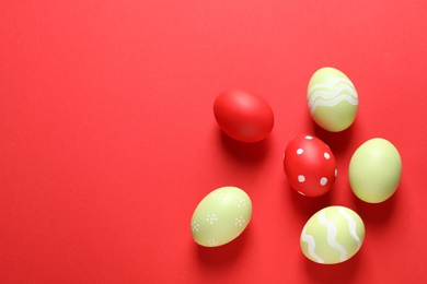 Photo of Flat lay composition with painted Easter eggs on color background, space for text