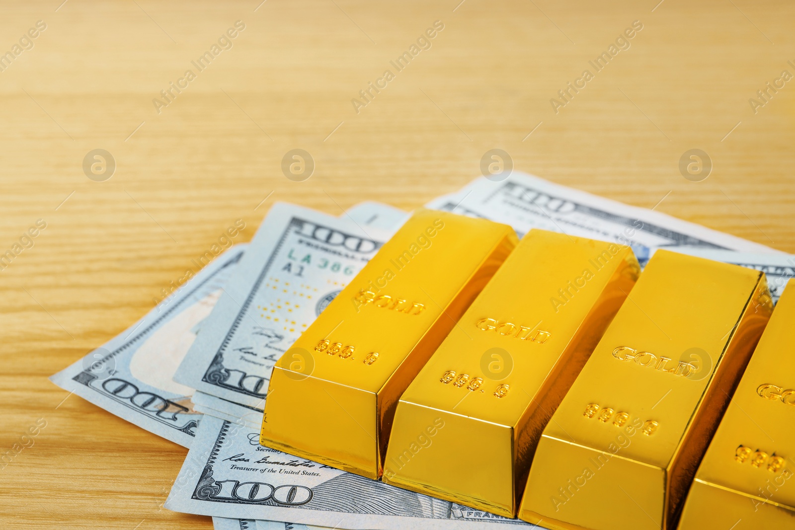 Photo of Gold bars and dollar bills on table, closeup. Space for text