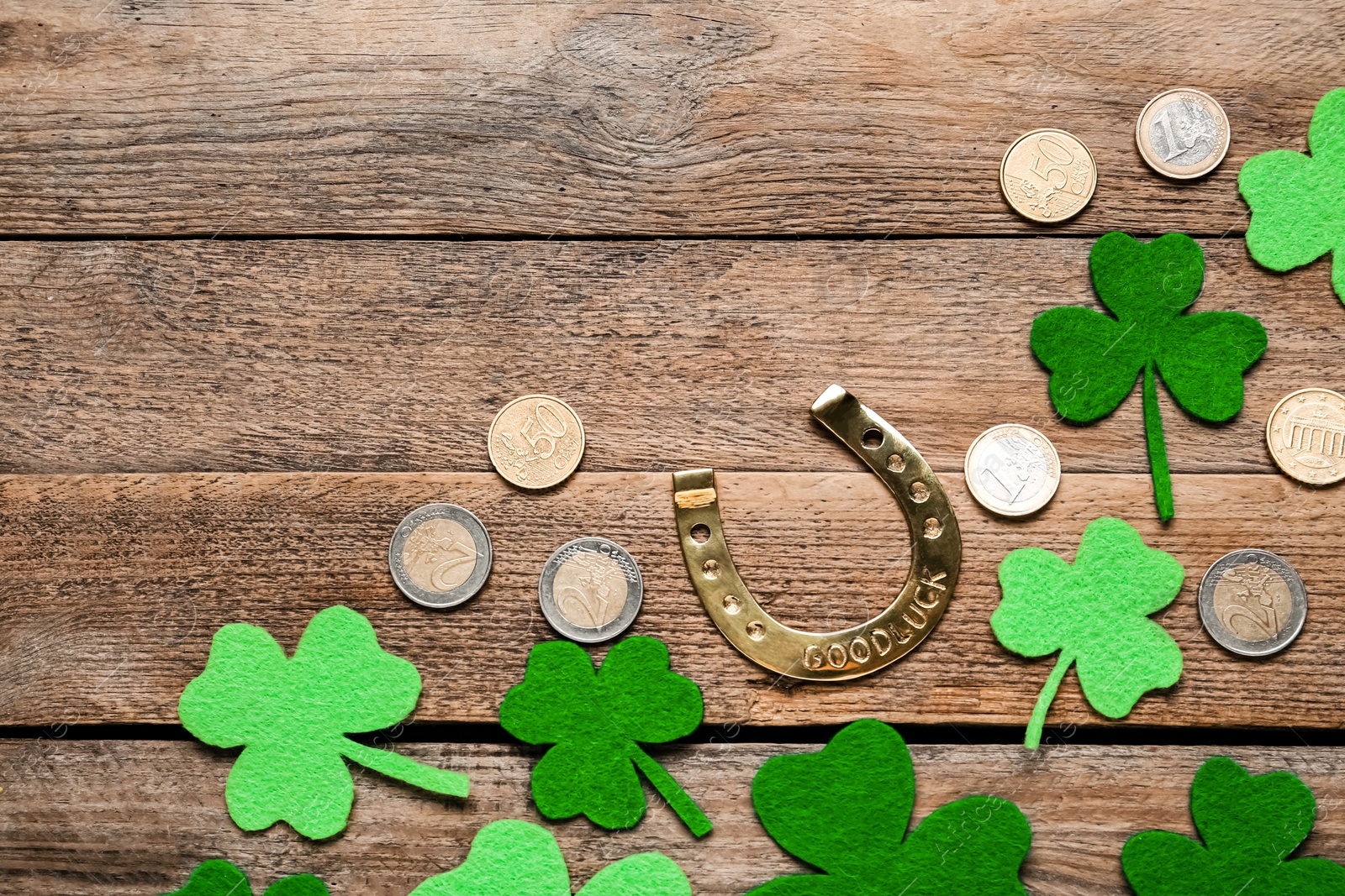 Photo of Flat lay composition with golden horseshoe on wooden table, space for text. Saint Patrick's Day celebration