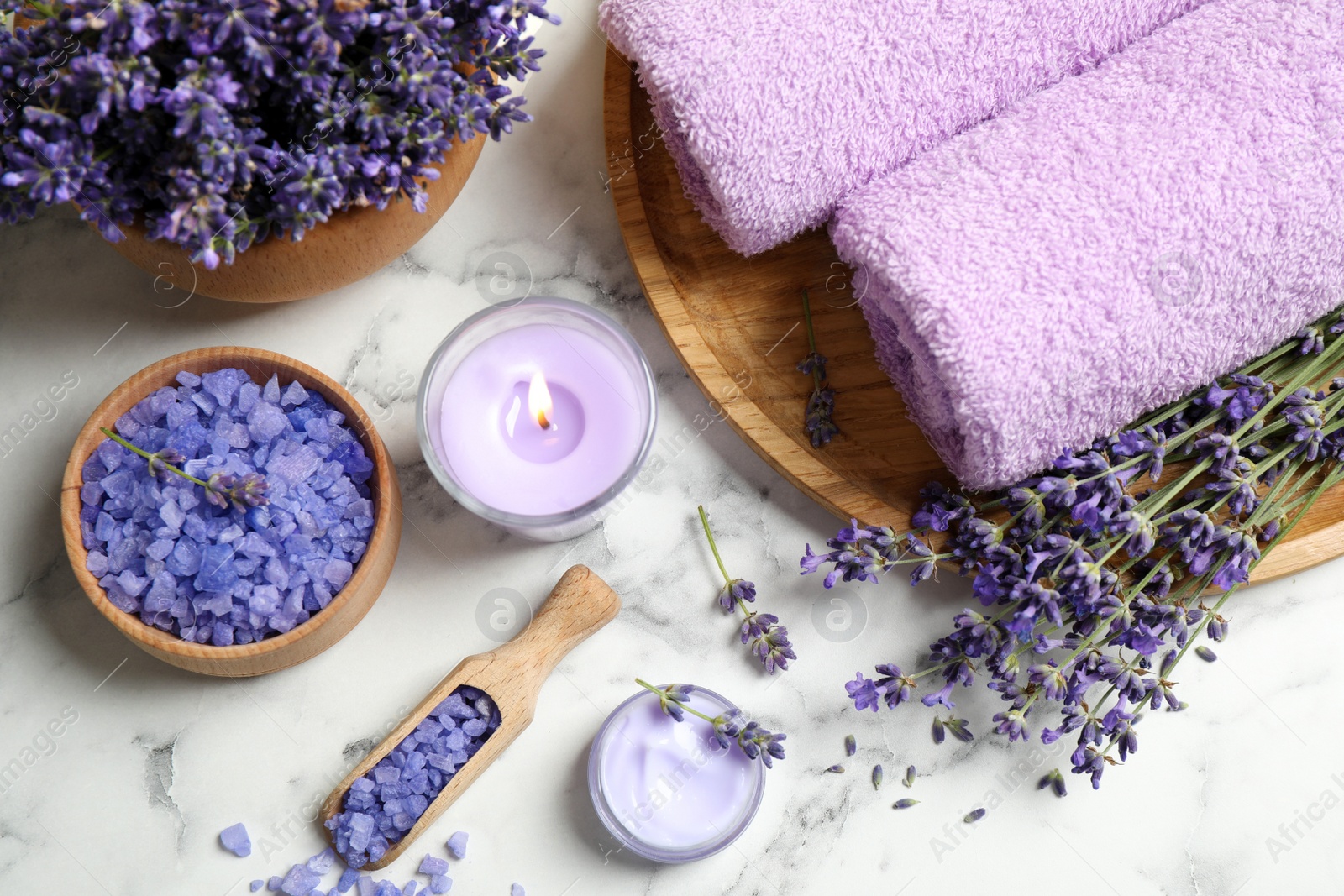 Photo of Cosmetic products and lavender flowers on white marble table, flat lay