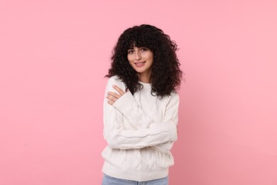 Photo of Happy young woman in stylish white sweater on pink background