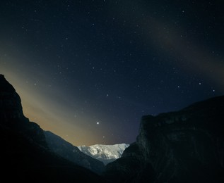 Picturesque view of night sky with many stars over mountains